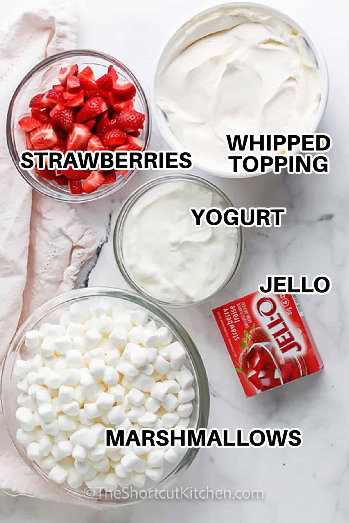 This strawberry fluff salad is an easy strawberry dessert made with Cool Whip, mini marshmallows, chopped strawberries, and strawberry Jello for a fluffy, creamy texture. It is a simple no-bake recipe that works well for cookouts, holidays, brunch, or any make-ahead dessert table. Add drained crushed pineapple for a classic variation or keep it simple and berry-forward. #theshortcutkitchen strawberries , whipped topping , yogurt , jello , marshmallows with labels to make Strawberry Fluff