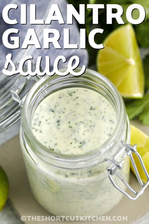 Cilantro garlic sauce brings a fresh, creamy boost to everyday meals. This easy homemade sauce blends sour cream, mayo, lime, and garlic with bright cilantro for the best flavor in every bite. It works as a dip, dressing, or drizzle for tacos, grilled chicken, roasted vegetables, and rice bowls. Keep a batch in the fridge and use it all week to add extra flavor without any extra effort. It is a simple way to prep make-ahead meals that taste super special. #theshortcutkitchen jar of Cilantro Garlic Sauce with a title