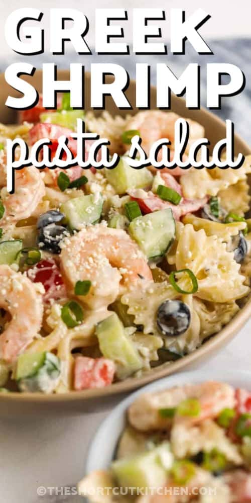 This Greek shrimp pasta salad recipe is a fresh and creamy shrimp pasta salad loaded with cucumber, tomatoes, green onions, feta, and olives. Bottled Greek dressing keeps the prep simple, making it a great shortcut recipe for warm-weather dinners, BBQ sides, or make-ahead lunches. Serve it as a side dish or enjoy it as a light main dish. #theshortcutkitchen bowl of Greek Shrimp Pasta Salad with writing
