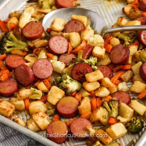 Sheet Pan Sausage and Veggies on the sheet pan with a spoon