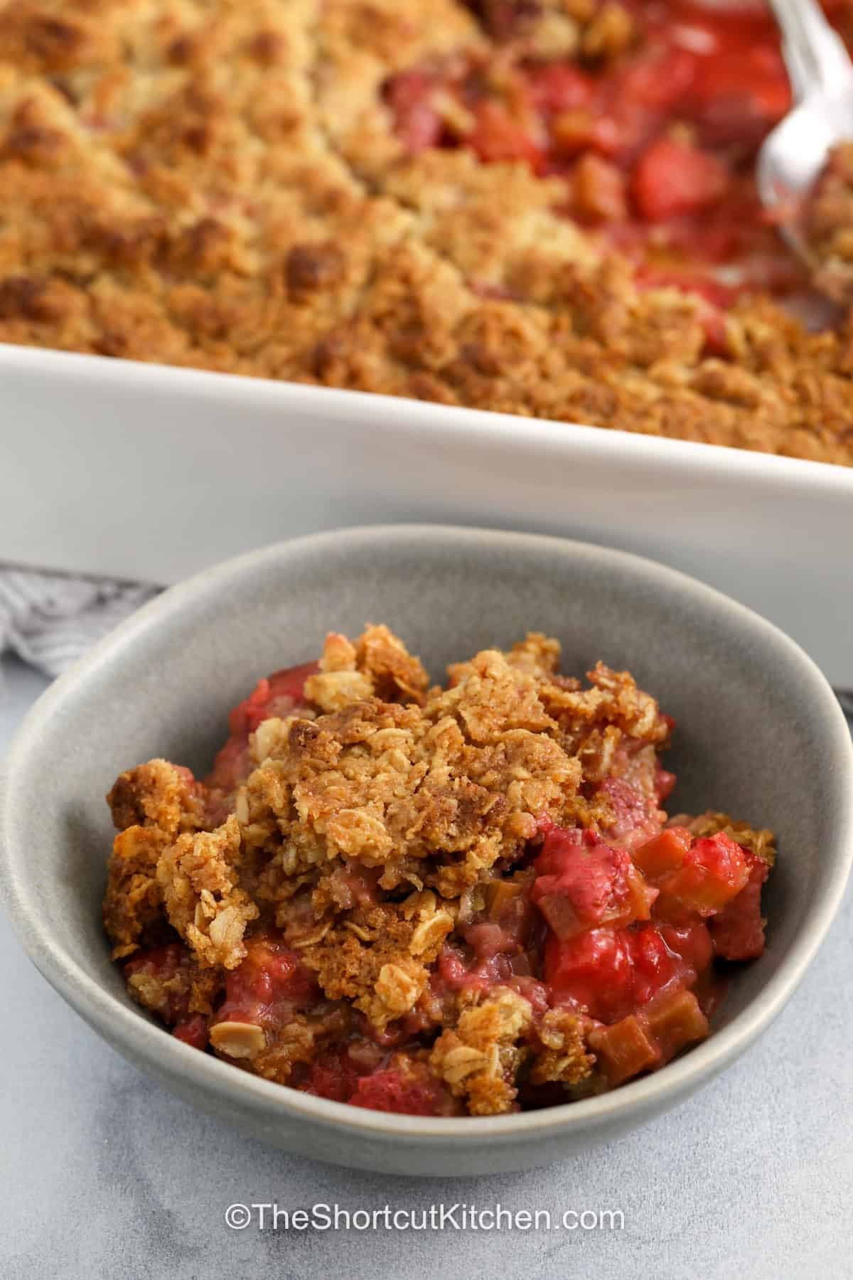 Strawberry rhubarb crisp is a simple dessert that highlights fresh fruit and a crisp topping. The sweet strawberries and tart rhubarb create a balanced flavor in every bite. A buttery cookie topping adds texture and bakes to a golden finish. This easy recipe is perfect for casual desserts or special occasions. It is a great choice when you want something homemade without a lot of effort in the kitchen. #theshortcutkitchen bowl of Strawberry Rhubarb Crisp