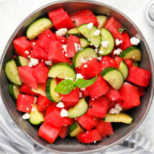 A bowl of watermelon cucumber salad with feta cheese and mint.