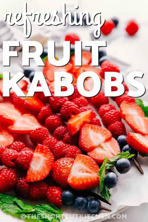 Make this easy fruit kabobs recipe with fresh strawberries, raspberries, blueberries, mint, and smooth melted chocolate. The berries are layered on skewers and finished with a chocolate drizzle for a pretty dessert that feels special with very little prep. Serve these kabobs at parties, on dessert boards, for after-school snacks, and for summer entertaining. #theshortcutkitchen refreshing Fruit Kabobs with writing