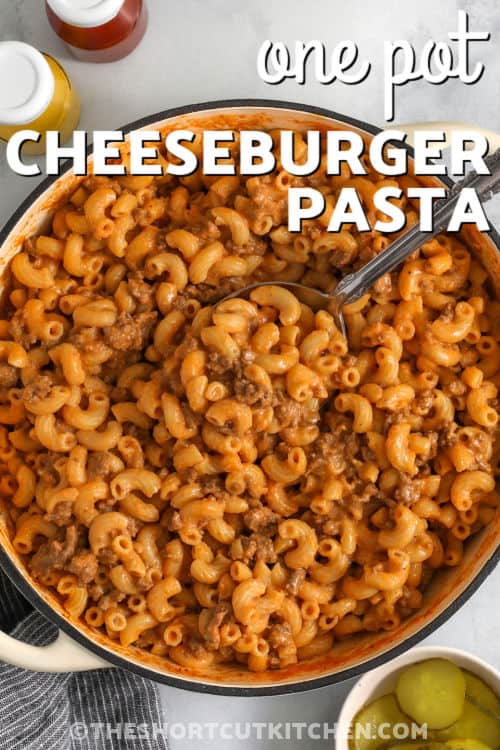 This Cheeseburger Pasta is an easy one-pot dinner made with ground beef, elbow macaroni, cheddar cheese, ketchup, and mustard. The pasta cooks right in the skillet, soaking up all that classic burger flavor. Ready in under 30 minutes, it’s creamy, cheesy, and perfect for a fast weeknight meal when you want comfort food without extra dishes. Pin this easy weeknight dinner now! #theshortcutkitchen One Pot Cheeseburger Pasta in the pot with a spoon and writing