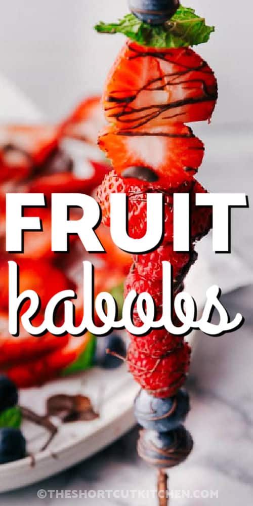 These chocolate fruit kabobs are made with juicy berries and fresh mint for a simple dessert that looks beautiful on any platter. Strawberries, blueberries, and raspberries are threaded onto skewers, then dipped and drizzled with melted chocolate. Make these fruit skewers for a fun no-bake option for brunch, baby showers, potlucks, cookouts, and holiday trays. #theshortcutkitchen close up of Fruit Kabobs with a title