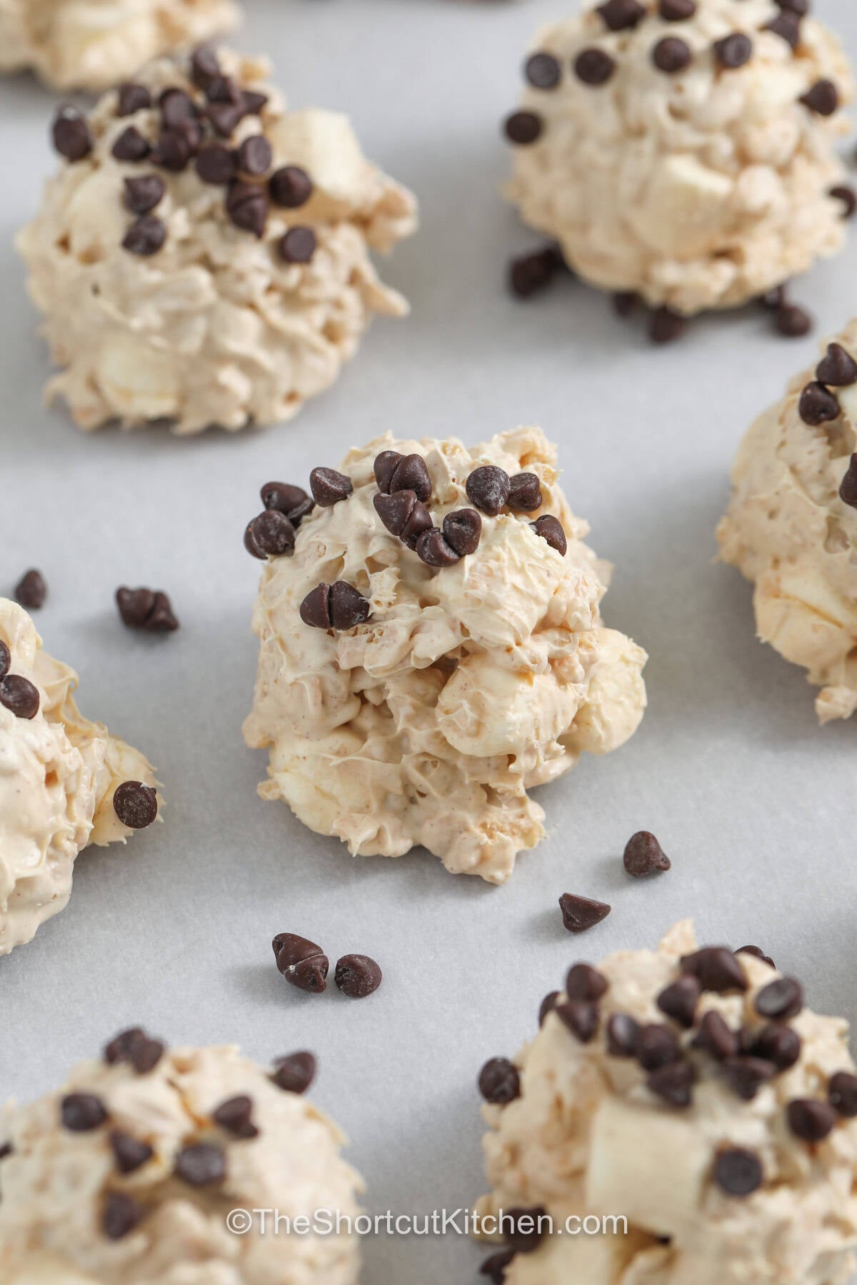 Easy and delicious, avalanche cookies are a no-bake favorite loaded with peanut butter, white chocolate, marshmallows, and crunchy cereal. Each cookie has the perfect mix of chewy centers and crisp texture that keeps everyone coming back for more. They are ideal for holidays, family gatherings, or last-minute desserts. With simple ingredients and big flavor, they are always a smart choice. Make them soon and enjoy every bite. #theshortcutkitchen close up of Avalanche Cookies on a sheet pan