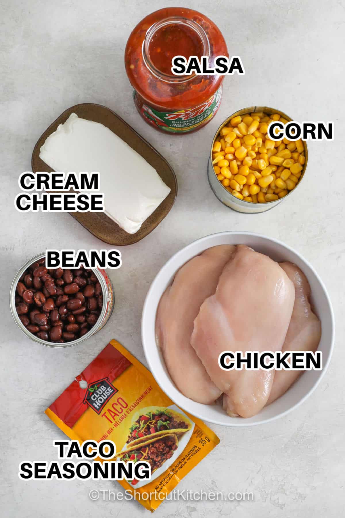 This fiesta chicken recipe takes simple pantry ingredients and turns them into a creamy Tex Mex dinner the whole family will enjoy. Chicken simmers with salsa, taco seasoning, corn, and black beans until tender enough to shred, then cream cheese is mixed in for a rich, creamy sauce. Serve it in tacos, bowls, wraps, or with chips for an easy meal any night of the week. Save this family favorite for dinner soon. #theshortcutkitchen chicken , corn , cream cheese , beans , taco seasoning and salsa with labels to make Fiesta Chicken Recipe