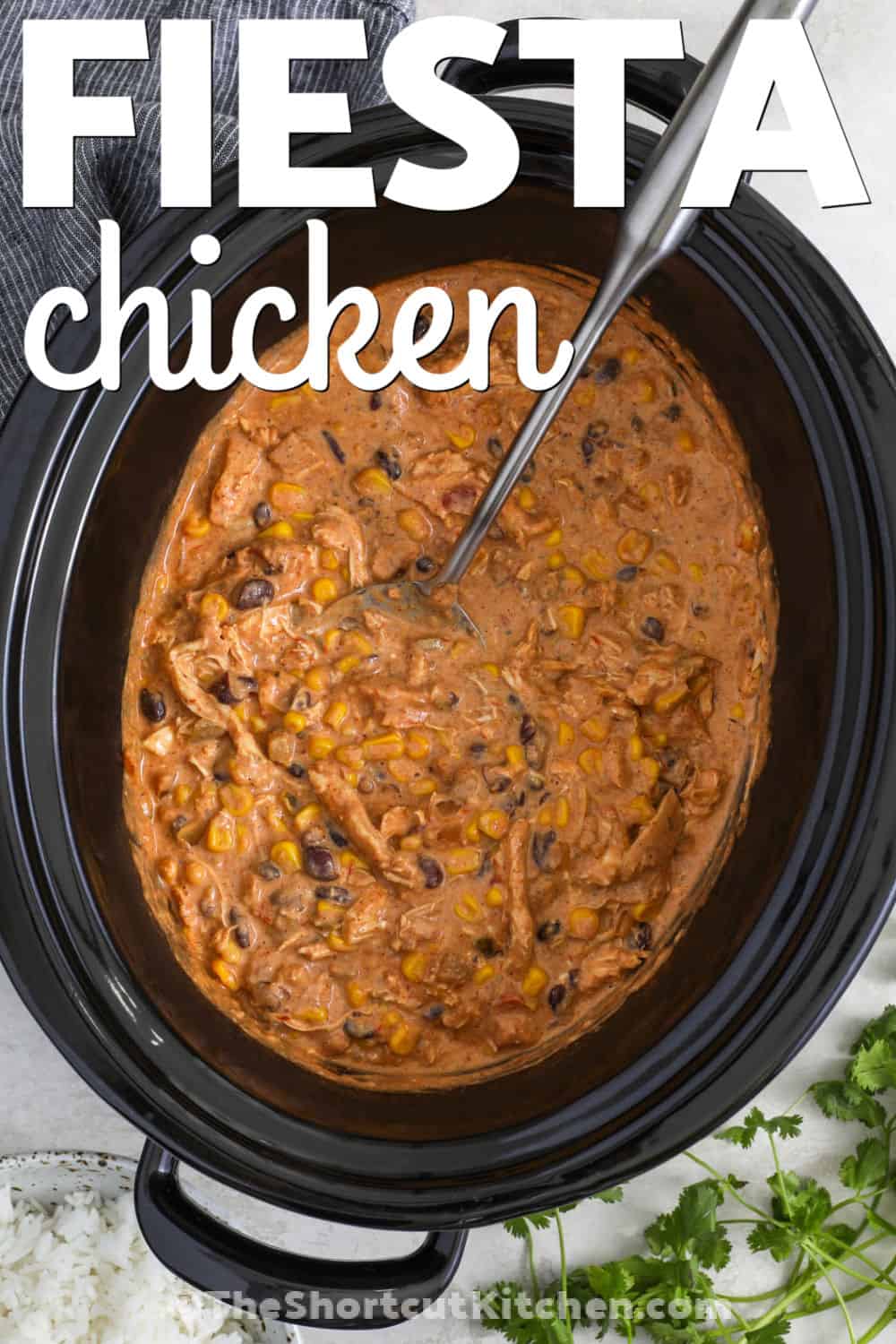 This fiesta chicken recipe is the easy dinner your family will ask for again and again. Tender shredded chicken cooks with salsa, taco seasoning, black beans, and corn for bold Tex-Mex flavor. Cream cheese is stirred in at the end to make every bite rich and creamy. Spoon it into tacos, burrito bowls, wraps, or over rice for a meal everyone can enjoy. Save this Slow Cooker Fiesta Chicken and add it to your dinner plans today. #theshortcutkitchen Fiesta Chicken Recipe in the crockpot with a title