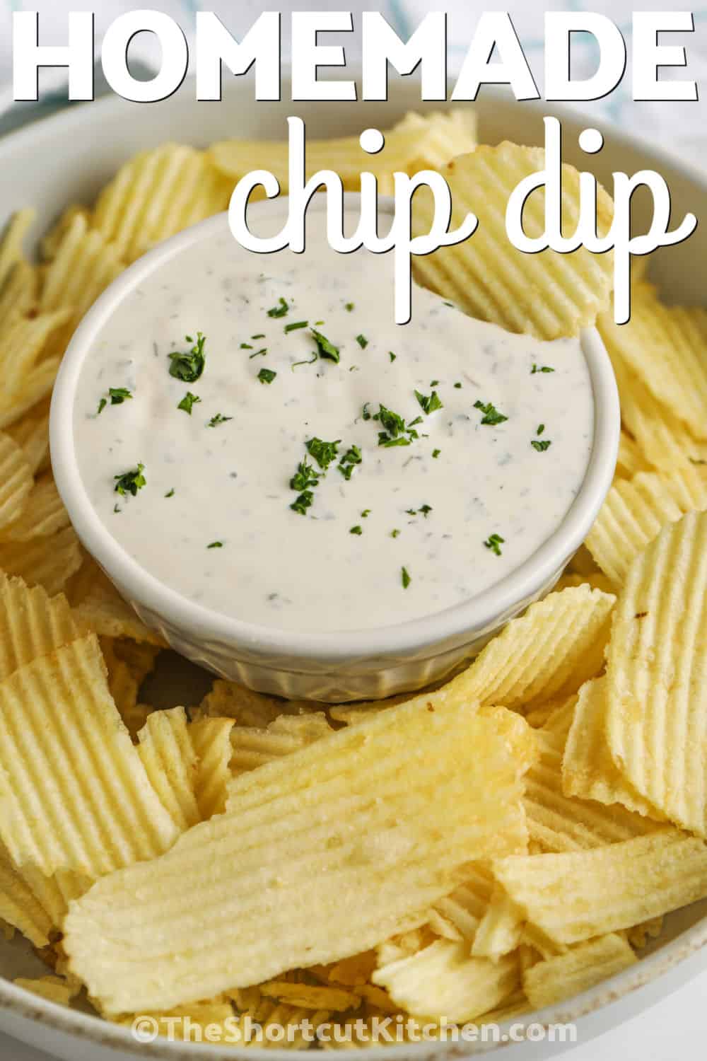 This Sour Cream homemade chip dip is a creamy cold dip made for potato chips, crackers, and fresh vegetables. The recipe uses mayonnaise for richness and pantry herbs for a fresh homemade flavor. Make this dip in minutes, chill it until serving, and add it to a snack board for parties, barbecues, school snacks, or easy weekend entertaining. Pin it for party planning. #theshortcutkitchen Homemade Chip Dip with ruffle chips and a title