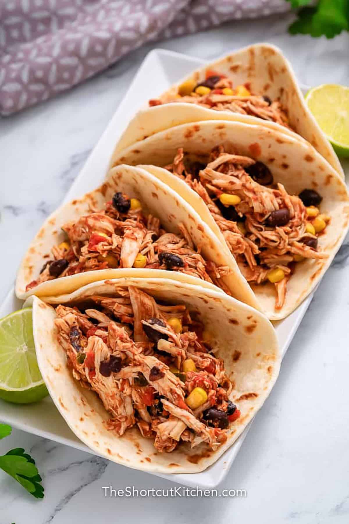 plate of Crockpot Shredded Chicken Tacos with lime