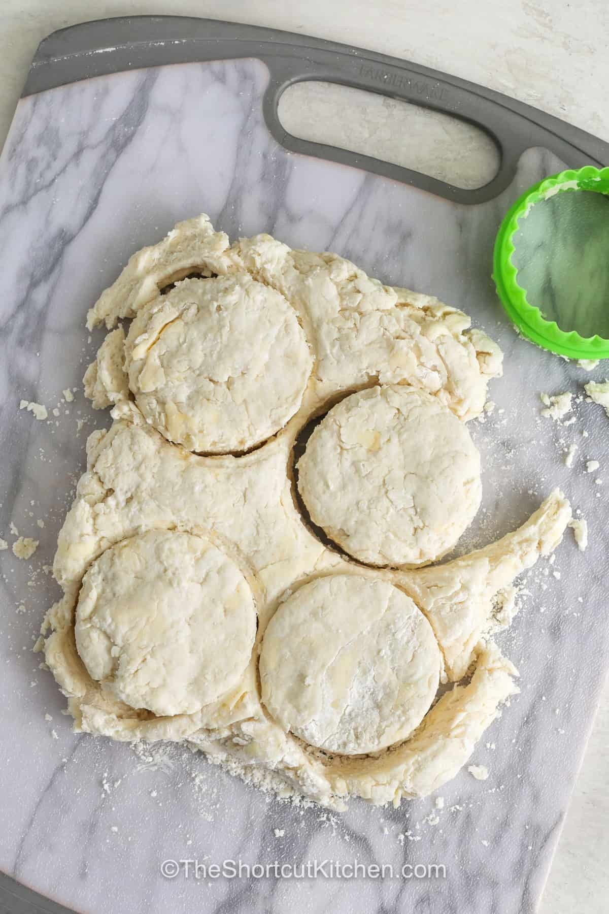 Need an easy side dish? 7up biscuits are a delicious choice for breakfast, lunch, or dinner. This simple biscuit recipe uses a few everyday ingredients to create tender, fluffy biscuits with plenty of buttery flavor. Serve them warm with your favorite meal, or add jam for a quick breakfast treat. They are also perfect alongside a bowl of soup or chili. Save this recipe and make a batch of 7up biscuits soon. #theshortcutkitchen cutting out biscuits from dough to make 7up Biscuits