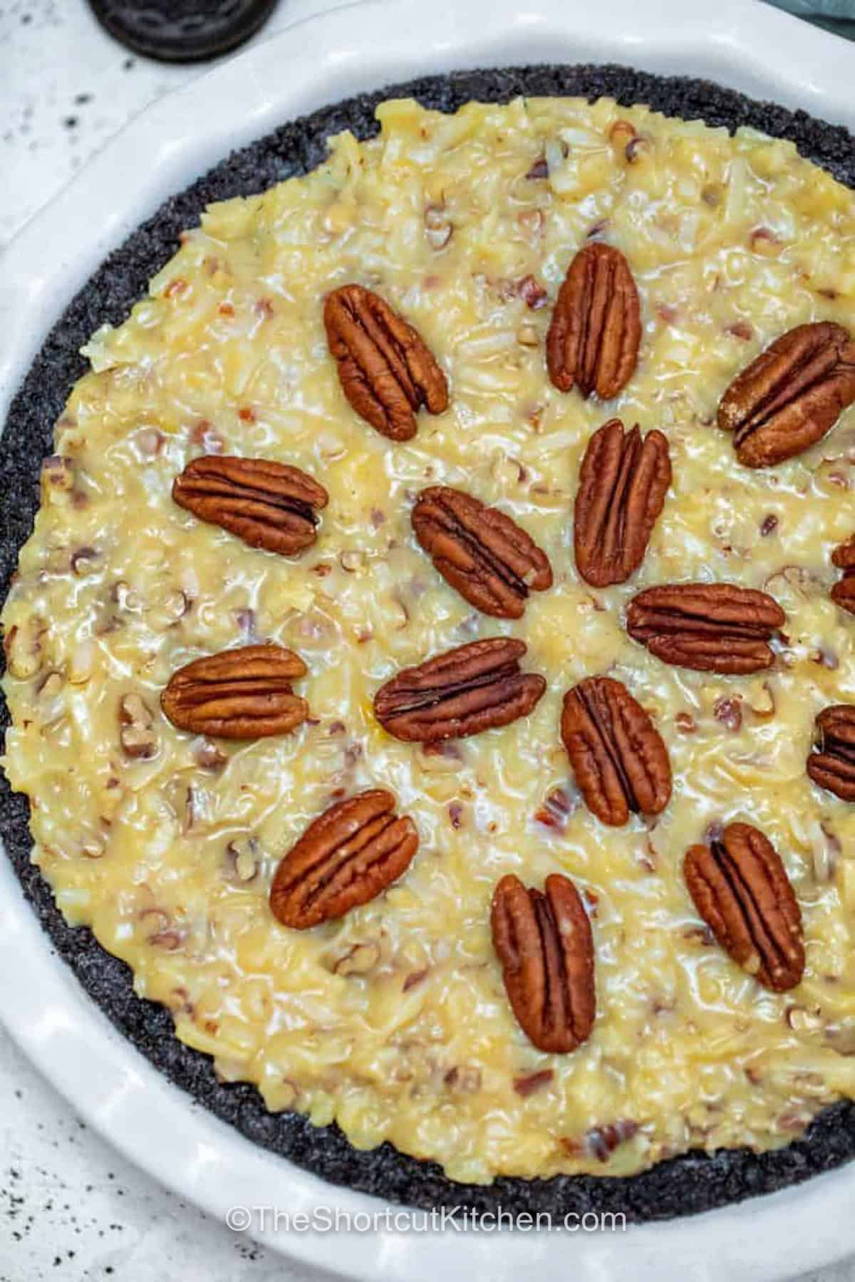 Try this German chocolate pie recipe when you want a rich chocolate dessert that is easier than a layer cake. The Oreo crust, creamy chocolate pecan layer, and sweet coconut topping make it perfect for Thanksgiving, Christmas, birthdays, or any gathering where chocolate and coconut are always welcome. Save this easy dessert idea. #theshortcutkitchen German Chocolate Pie with pecans