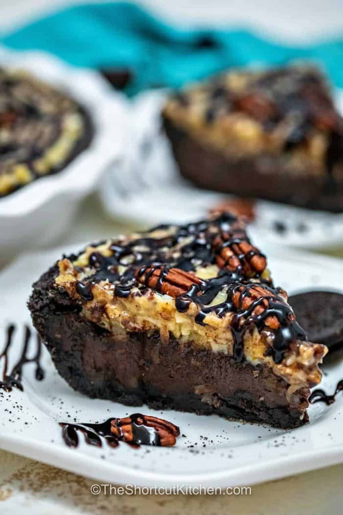 This German chocolate pie is a rich chilled dessert with an Oreo crust, creamy German sweet chocolate filling, chopped pecans, and a gooey coconut pecan topping. This German Chocolate Pie Recipe is perfect for holidays, potlucks, birthdays, and make-ahead entertaining when you want a chocolate dessert that slices beautifully. Save this recipe for your next celebration. #theshortcutkitchen slices of German Chocolate Pie on plates