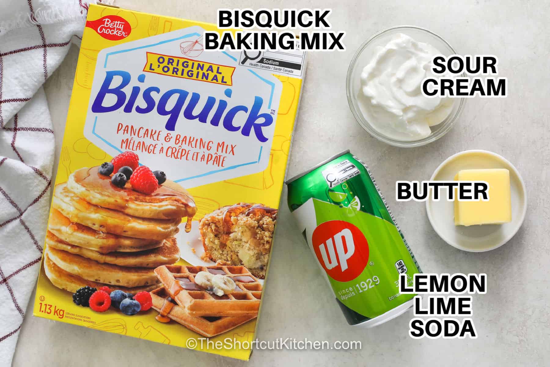 7up biscuits are an easy way to enjoy warm, homemade bread with any meal. Bisquick and a few simple ingredients come together with sour cream, cold butter, and lemon-lime soda for fluffy, flavorful biscuits. Serve them with breakfast, pair them with soup or chili, or spread them with butter and jam. Keep this easy biscuit recipe handy whenever you want a simple homemade side. Try 7up biscuits for your next meal. #theshortcutkitchen lemon lime soda , butter , sour cream and Bisquick baking mix with writing to make 7up Biscuits