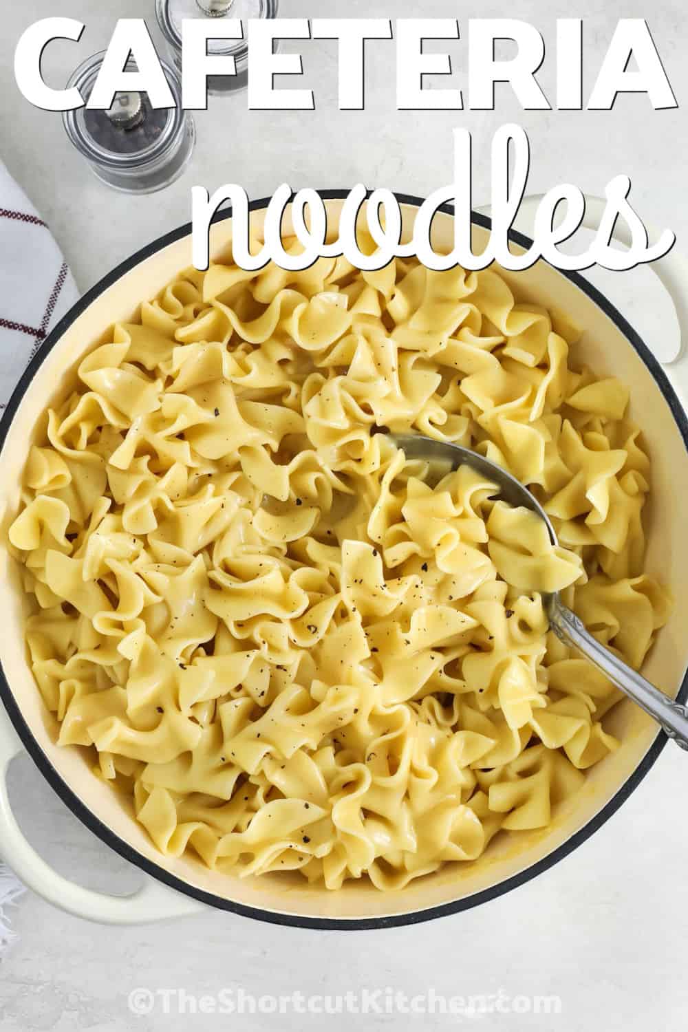 Cozy cafeteria noodles are the perfect addition to any comforting home cooked meal. This easy noodle recipe combines tender egg noodles with creamy chicken soup, rich broth, and buttery flavor for a side dish everyone loves. They are a wonderful choice for holidays, family dinners, or anytime you want a simple dish with classic flavor. Add this recipe to your menu and make a bowl of delicious cafeteria noodles soon. #theshortcutkitchen pot of Cafeteria Noodles with a spoon and writing