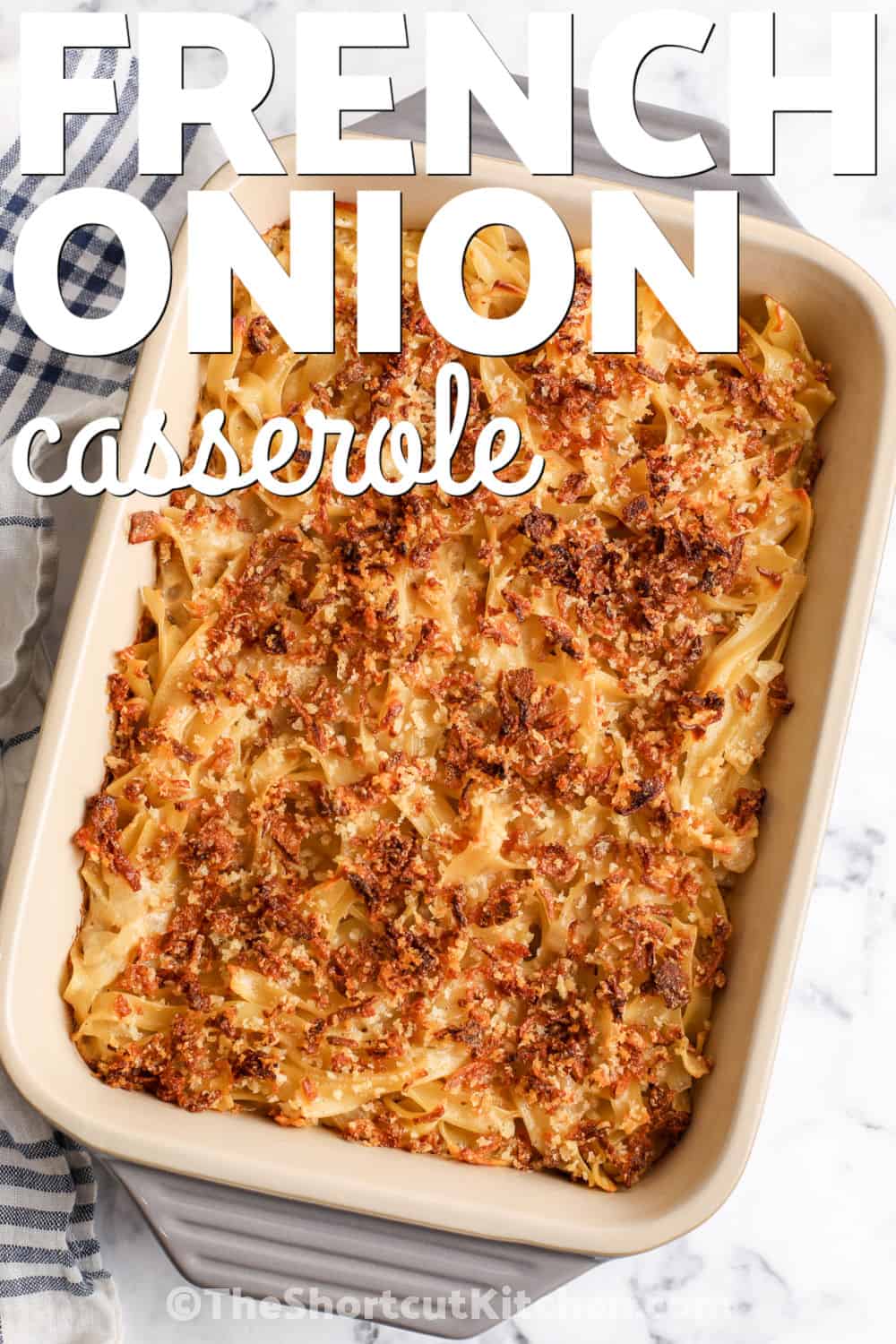 Looking for an easy casserole made with egg noodles and everyday ingredients. This French onion casserole combines sautéed yellow onion, savory beef broth, and creamy French onion dip in a quick stovetop sauce. It is topped with Parmesan, Panko, and French fried onions before baking until hot and golden. This budget-friendly onion noodle casserole is simple to customize. Pin it for an easy comfort food dinner. #theshortcutkitchen casserole dish with French Onion Casserole and a title