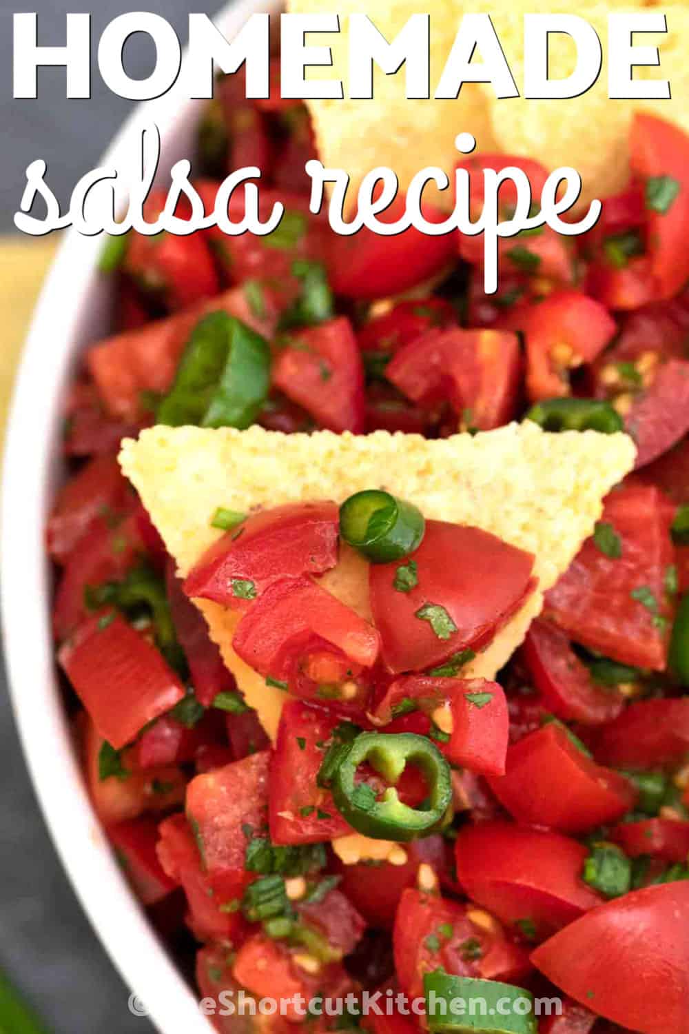 This chunky homemade salsa recipe is a quick and easy way to use cherry tomatoes, fresh cilantro, jalapeños, lime, and garlic. It has bold fresh flavor, a mild kick, and a juicy texture that is perfect for scooping. Make this no-cook salsa for game day, taco night, summer parties, or as a simple topping for nachos, eggs, burritos, grilled meats, and salads. Pin it for your next party snack. #theshortcutkitchen Homemade Salsa Recipe on a tortilla chip with bowl full and a title