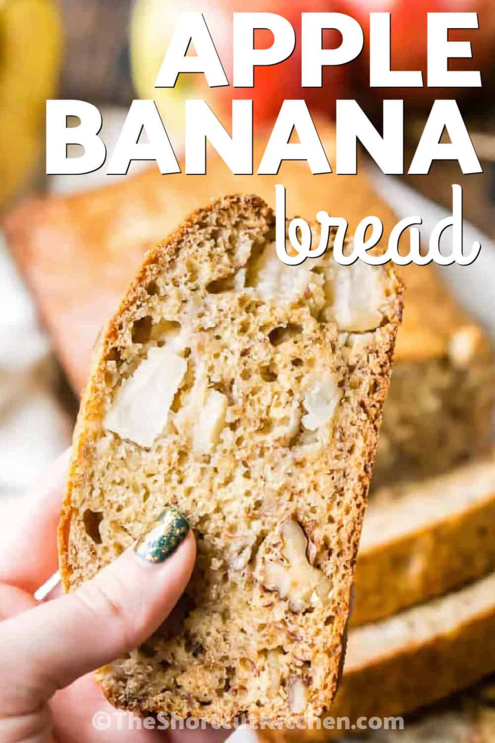 Fresh apple makes this apple banana bread extra flavorful and deliciously moist. Mashed ripe bananas, brown sugar, Greek yogurt, vanilla, chopped apple, and walnuts are folded into an easy quick bread batter and baked into a tender homemade loaf. Serve thick slices for breakfast, brunch, snacks, or a simple dessert. This apple walnut banana bread is also easy to freeze by the slice. Pin the recipe for later. #theshortcutkitchen close up of holding a slice of Apple Banana Bread with a title
