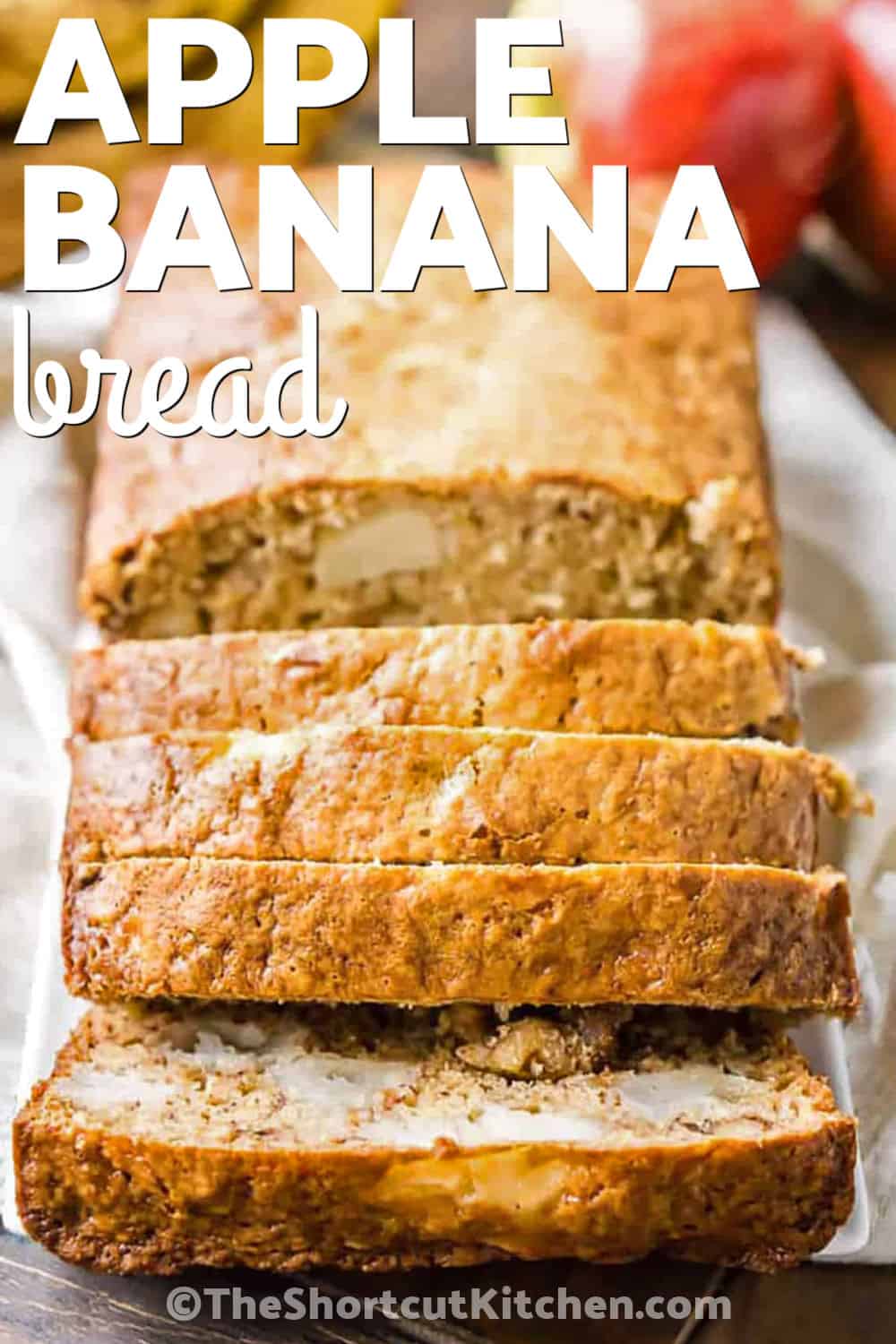 Banana bread with apples is an easy way to make a classic loaf even more moist and flavorful. This apple banana bread combines ripe mashed bananas with fresh chopped apple, Greek yogurt, brown sugar, and walnuts. The batter takes only about 10 minutes to prepare before baking into a tender quick bread with plenty of fruit in every slice. Make it for breakfast, brunch, or snacking. Pin this easy quick bread recipe for later. #theshortcutkitchen Apple Banana Bread on a plate with slices cut out with a title