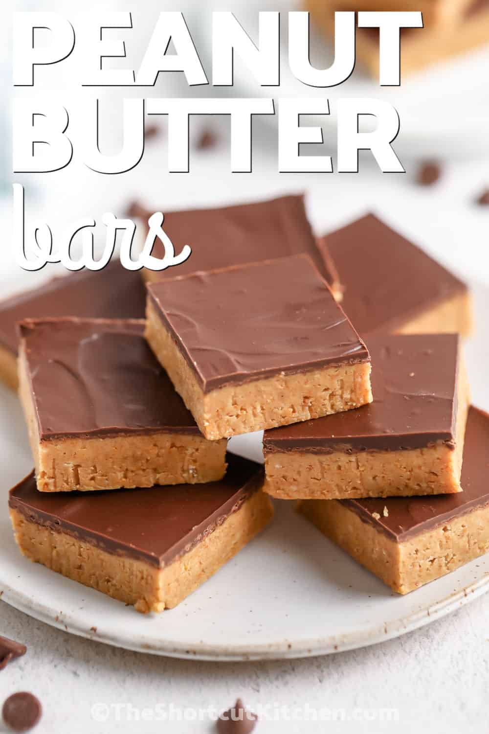 Rich, creamy, and topped with smooth chocolate, this peanut butter bars recipe comes together with everyday ingredients and chills into perfectly sliceable dessert bars. They're ideal for bake sales, potlucks, and freezer-friendly treats. Pin it now. #theshortcutkitchen plated Peanut Butter Bars with writing