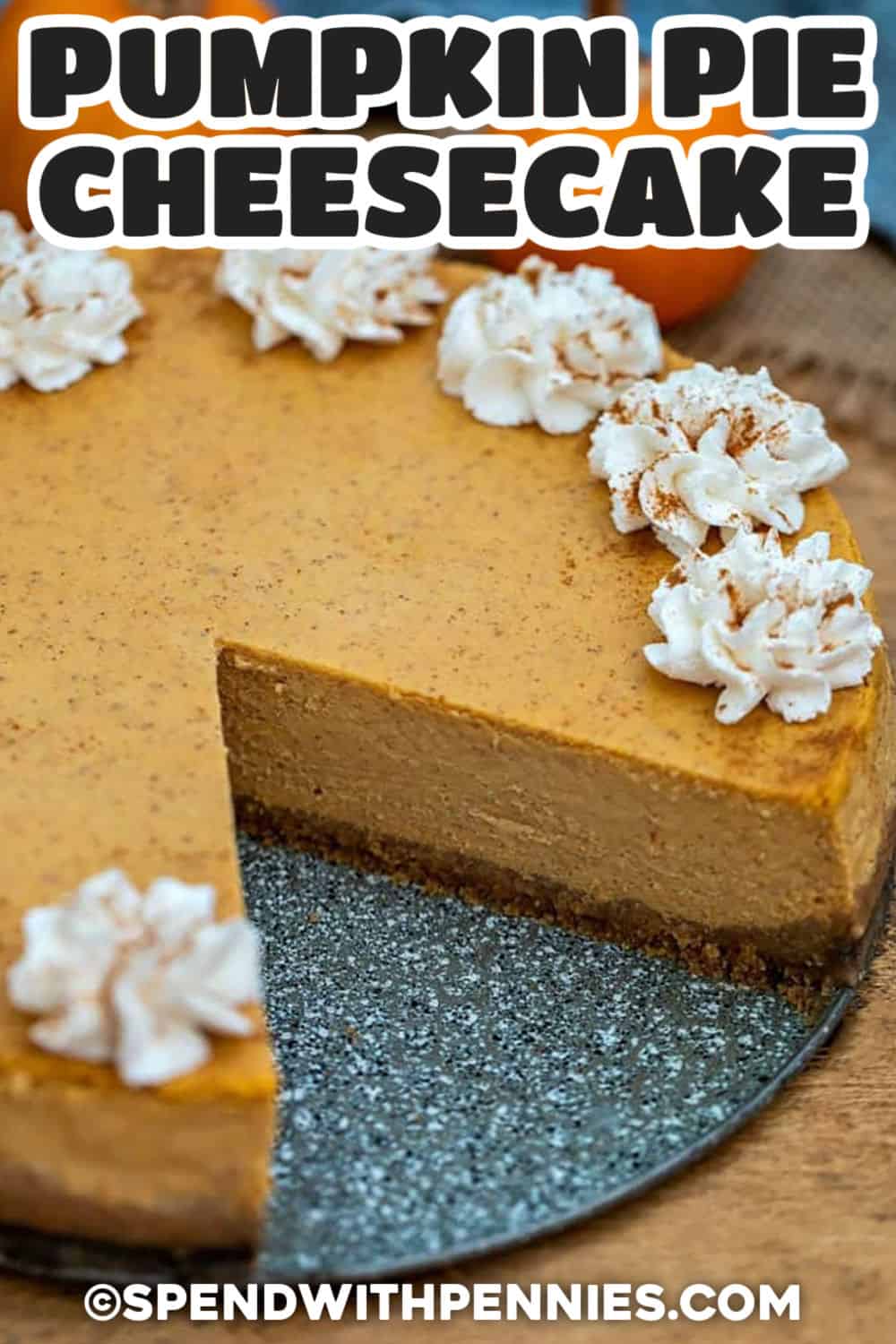 Looking for a pumpkin dessert that can be prepared before the holiday rush. Pumpkin pie cheesecake layers a spiced graham cracker crust with creamy cream cheese and pumpkin pie filling, then bakes slowly for a smooth finish. An overnight chill makes it ideal for planning ahead, and whipped cream adds an easy final touch. Pin this baked pumpkin cheesecake for your Thanksgiving dessert menu. #theshortcutkitchen Pumpkin Pie Cheesecake with a slice taken out and writing