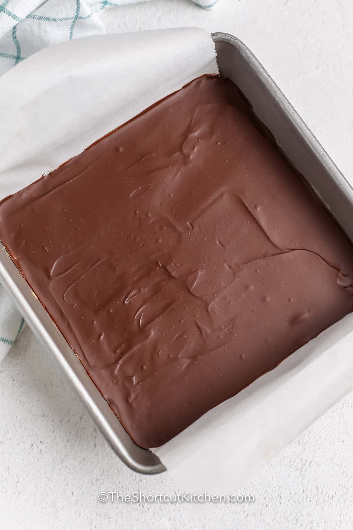 Make bakery-style peanut butter bars recipe at home with just a few pantry ingredients. The smooth peanut butter filling and chocolate topping create a dessert that's perfect for parties, after-school snacks, or gifting. Pin this simple no-bake recipe. #theshortcutkitchen Peanut Butter Bars in the pan