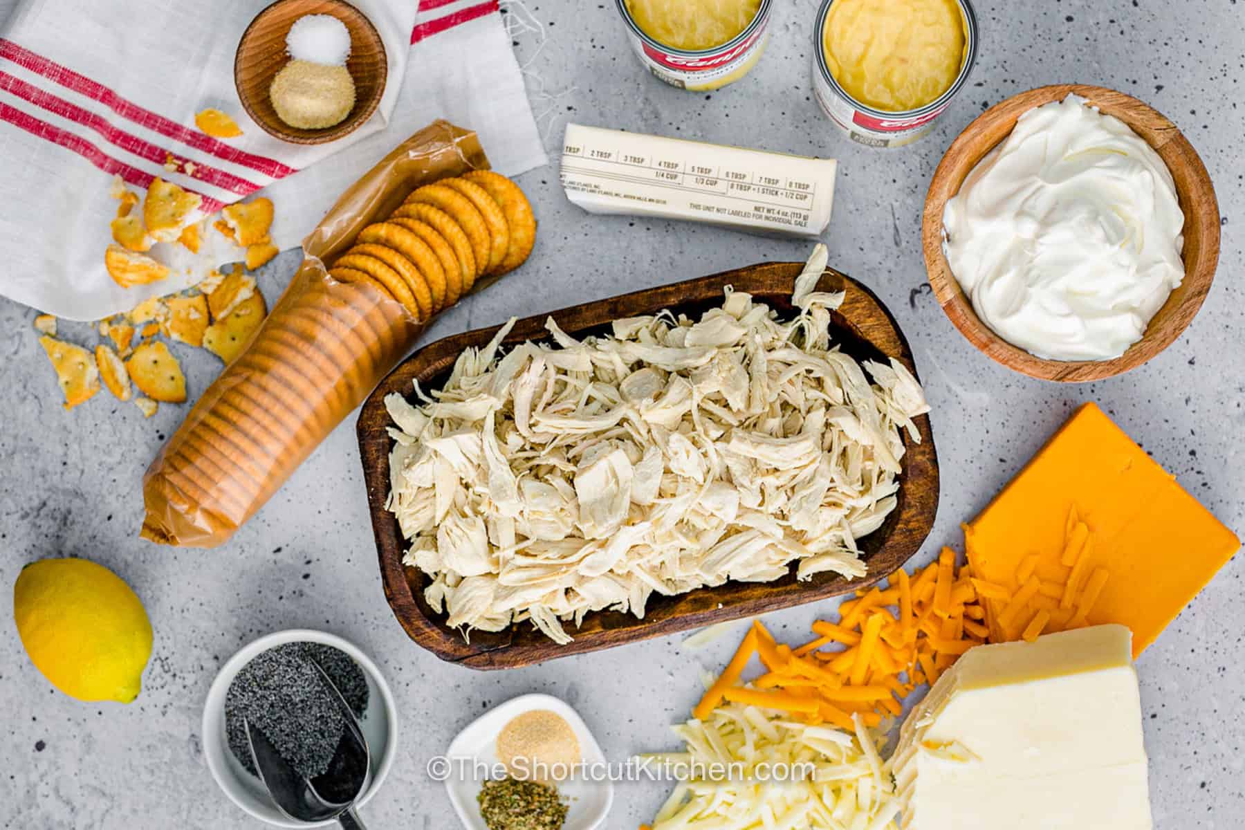 Chicken poppyseed casserole is an easy oven-baked dinner filled with tender shredded chicken, creamy Greek yogurt, cream of chicken soup, cheddar, mozzarella, and poppy seeds. A buttery Ritz cracker topping bakes until crisp and golden for the perfect creamy-crunchy combination. Use rotisserie chicken to keep prep to just 5 minutes and serve this cozy chicken casserole with rice or vegetables. Save this easy dinner recipe for later. #theshortcutkitchen Chicken Poppyseed Casserole ingredients.