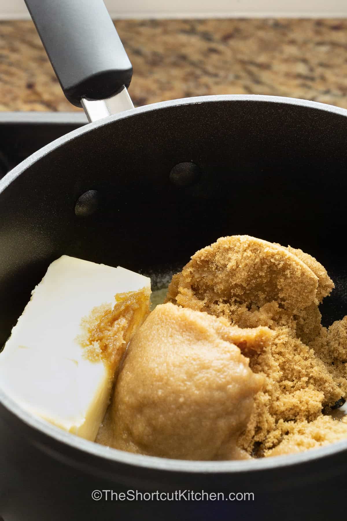 Easy caramel sauce is a simple 3 ingredient recipe made with brown sugar, butter, and milk. Everything cooks together in one saucepan for a rich, smooth caramel sauce that's easy enough for beginner cooks. Serve it warm as an ice cream topping, drizzle it over brownies, or pair it with apples and fall desserts. Keep this homemade brown sugar caramel sauce handy and pin the recipe today. #theshortcutkitchen ingredients to make Easy Caramel Sauce in a pot.