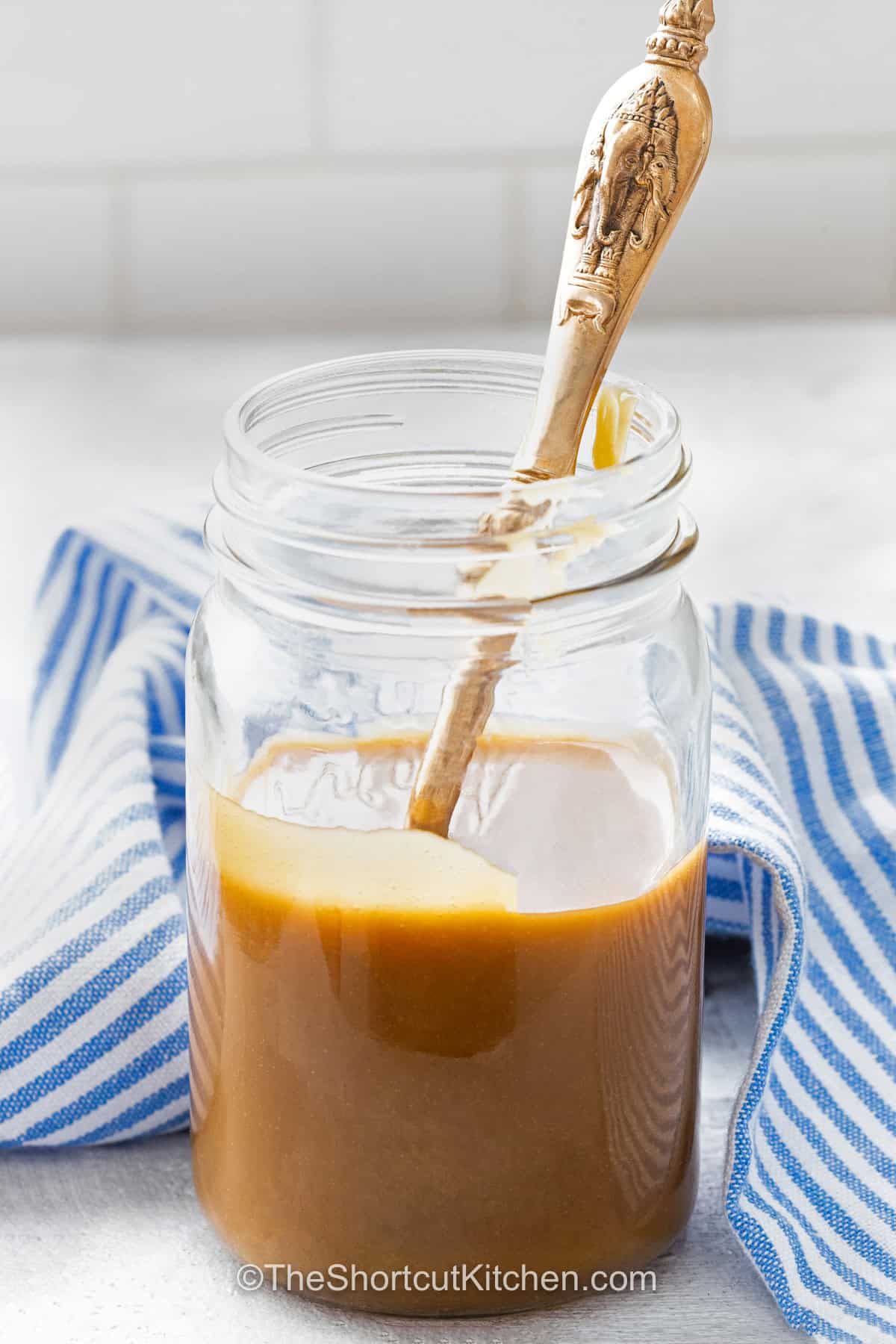 A warm drizzle of easy caramel sauce can turn the simplest dessert into something special. Made with butter, brown sugar, and milk, this quick stovetop caramel is buttery, smooth, and wonderfully rich. There is no candy thermometer or complicated sugar caramelizing needed. Use this homemade caramel sauce for ice cream, baked apples, cakes, or breakfast treats. Save the recipe and make a batch. #theshortcutkitchen jar of Easy Caramel Sauce.