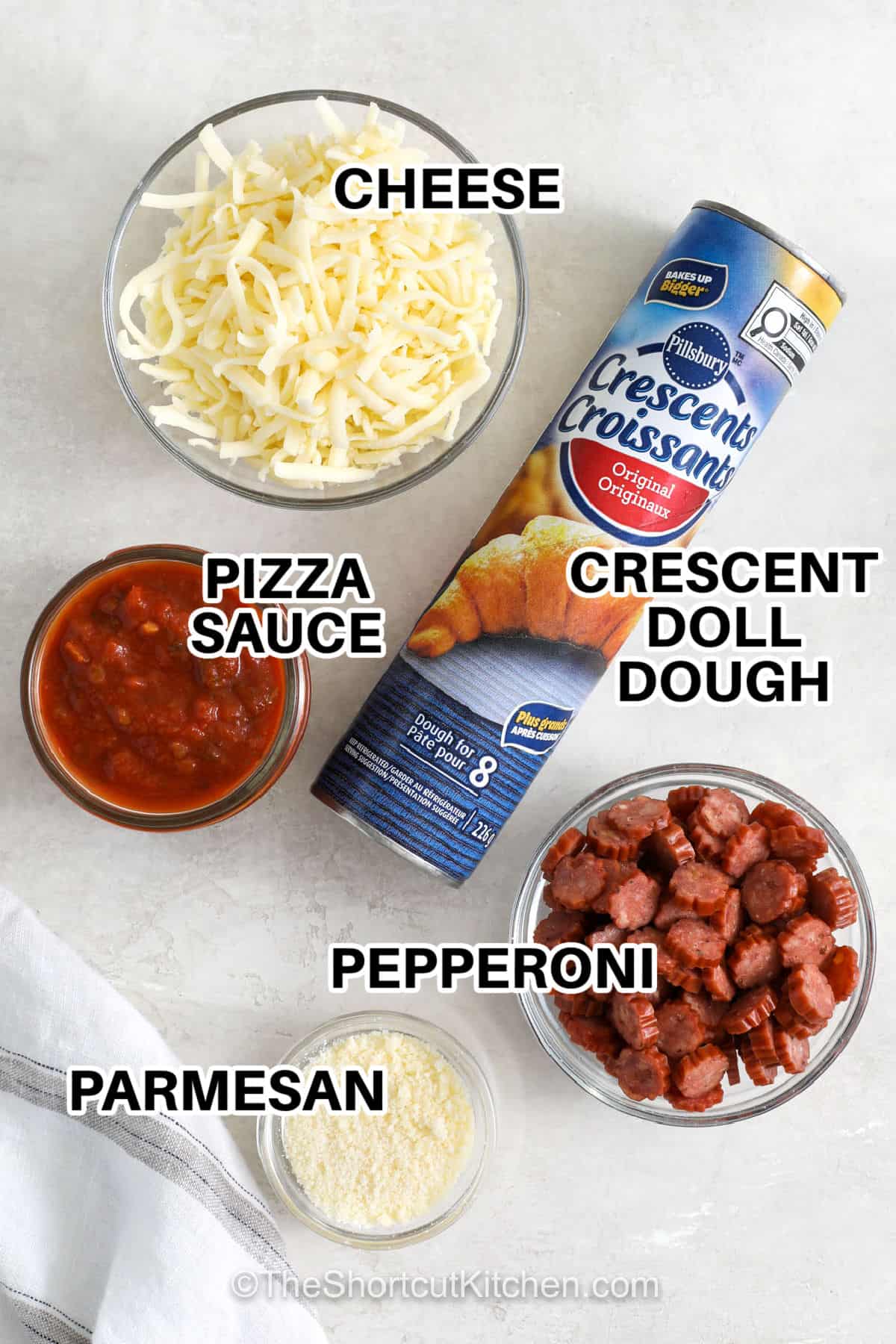 Pizza cupcakes bring all the best parts of pizza together in a fun muffin tin snack. Flaky crescent dough holds a layer of pizza sauce, shredded mozzarella, and mini pepperoni, then gets a sprinkle of Parmesan. They are simple enough for a family snack and fun enough for parties or game day. Use your favorite pizza toppings for an easy twist. Add these pizza cupcakes to your menu today. #theshortcutkitchen cheese , pizza sauce , parmesan , crescent roll dough and pepperoni with labels to make Pizza Cupcakes.