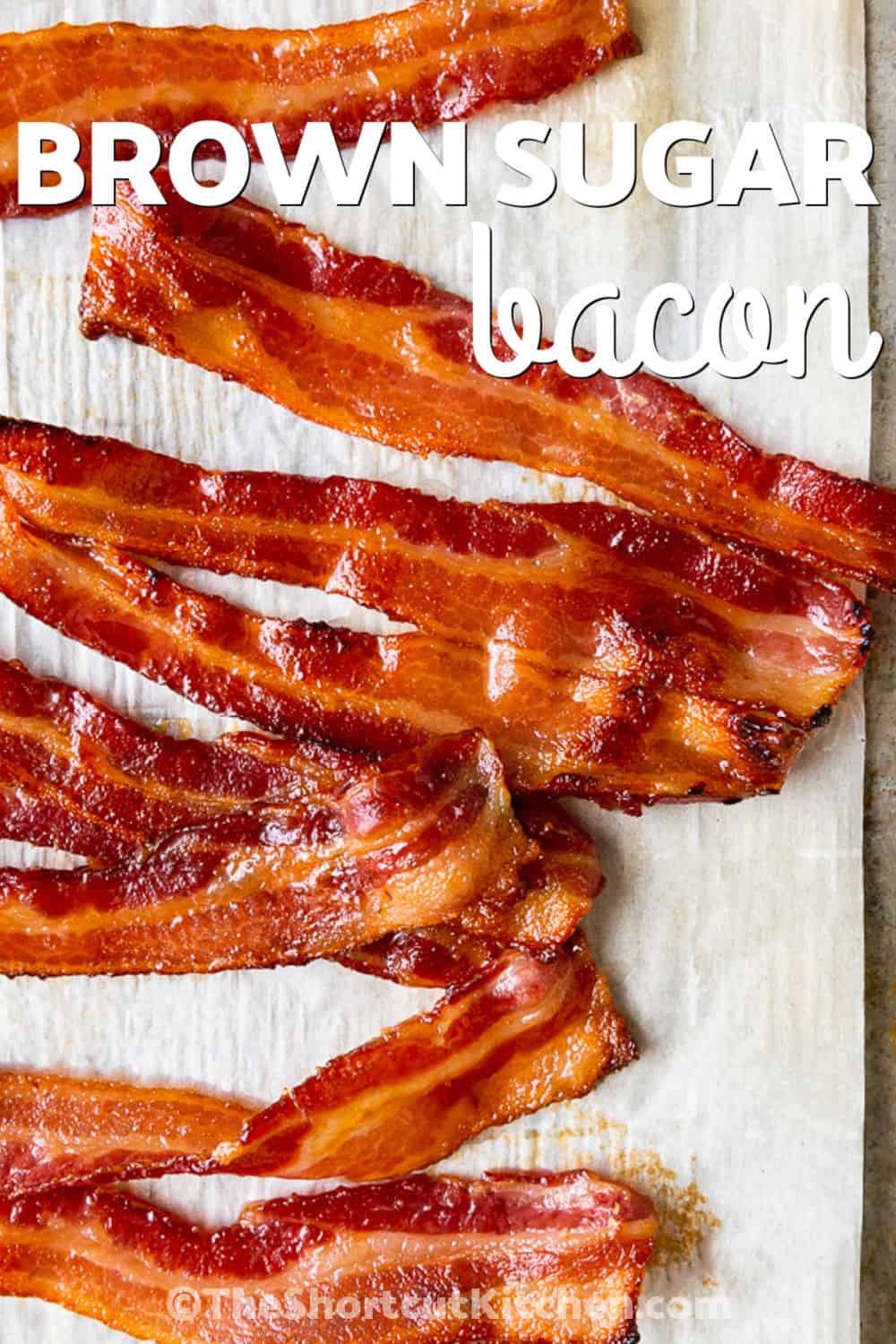 Sweet and savory brown sugar bacon is an easy way to make breakfast extra special. Brown sugar caramelizes over the bacon as it cooks, creating crisp edges and a delicious coating. This simple candied bacon pairs beautifully with eggs, pancakes, waffles, and French toast. It is also a tasty addition to brunch spreads and holiday breakfasts. With just two ingredients, this easy recipe makes classic bacon even more tempting. Make it for your next breakfast. #theshortcutkitchen cooked brown sugar bacon with a title.