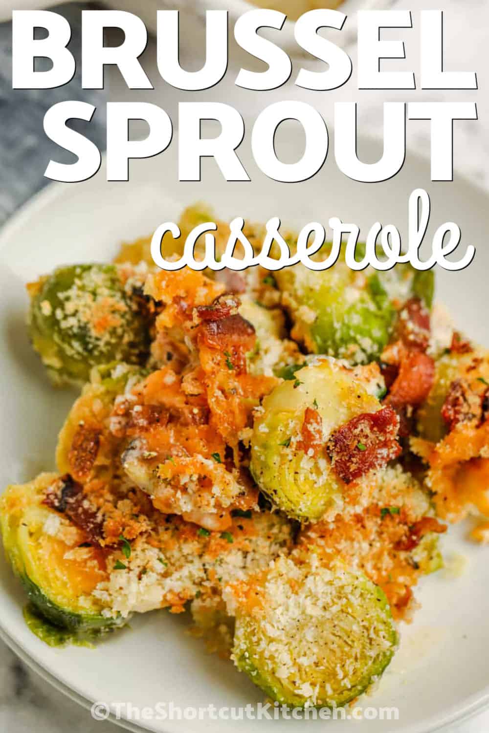 Easy Brussels sprout casserole is a creamy oven-baked side made with fresh Brussels sprouts, crisp bacon, cheddar cheese, heavy cream, and panko breadcrumbs. Every serving has tender sprouts underneath and a crunchy golden topping. Ready in just 30 minutes, this Brussels sprouts casserole with bacon works for busy dinners and holiday entertaining. Save this easy side dish recipe and make it soon. #theshortcutkitchen plated Brussel Sprout Casserole with a title.