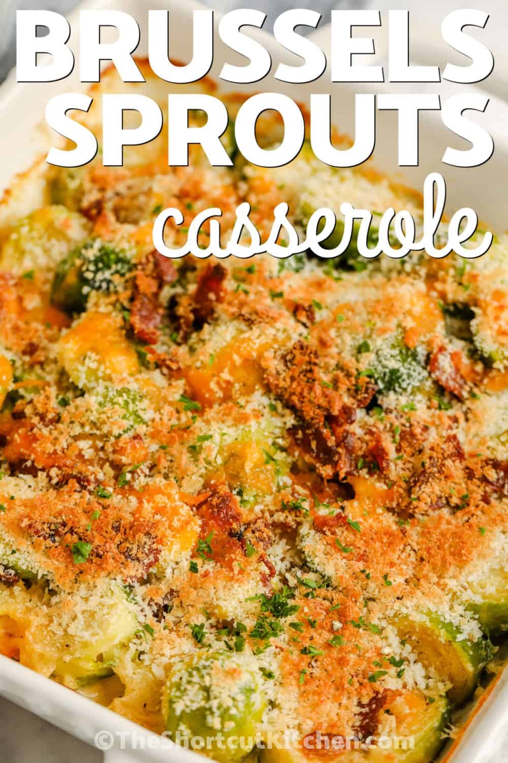 Baked Brussel sprout casserole makes fresh Brussels sprouts rich, creamy, and extra savory with cheddar cheese and bacon. Panko breadcrumbs add a crispy finish while a short baking time keeps this side dish easy enough for weeknights. Serve this creamy Brussels sprout casserole for Thanksgiving, Christmas, Easter, or with a simple roast dinner. Pin this 30-minute casserole for your next menu. #theshortcutkitchen cheesy Brussel Sprout Casserole in a dish with a title.