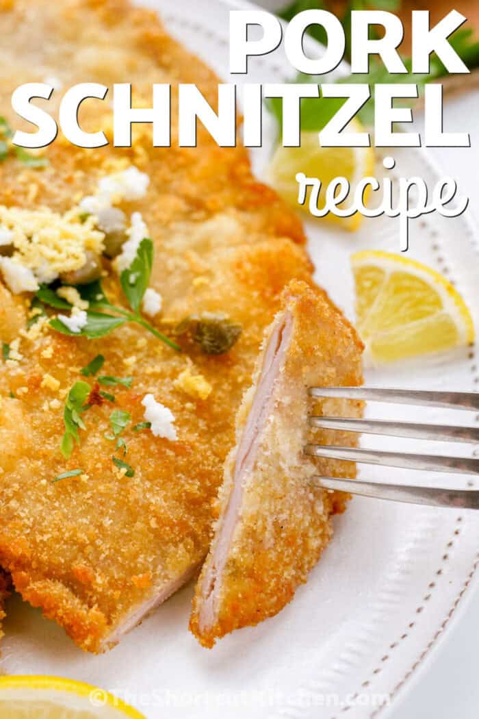 crunchy Pork Schnitzel Recipe with lemon and writing.