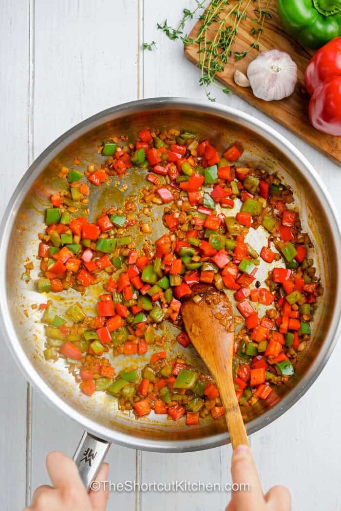 peppers and onions sautéed in a pan.