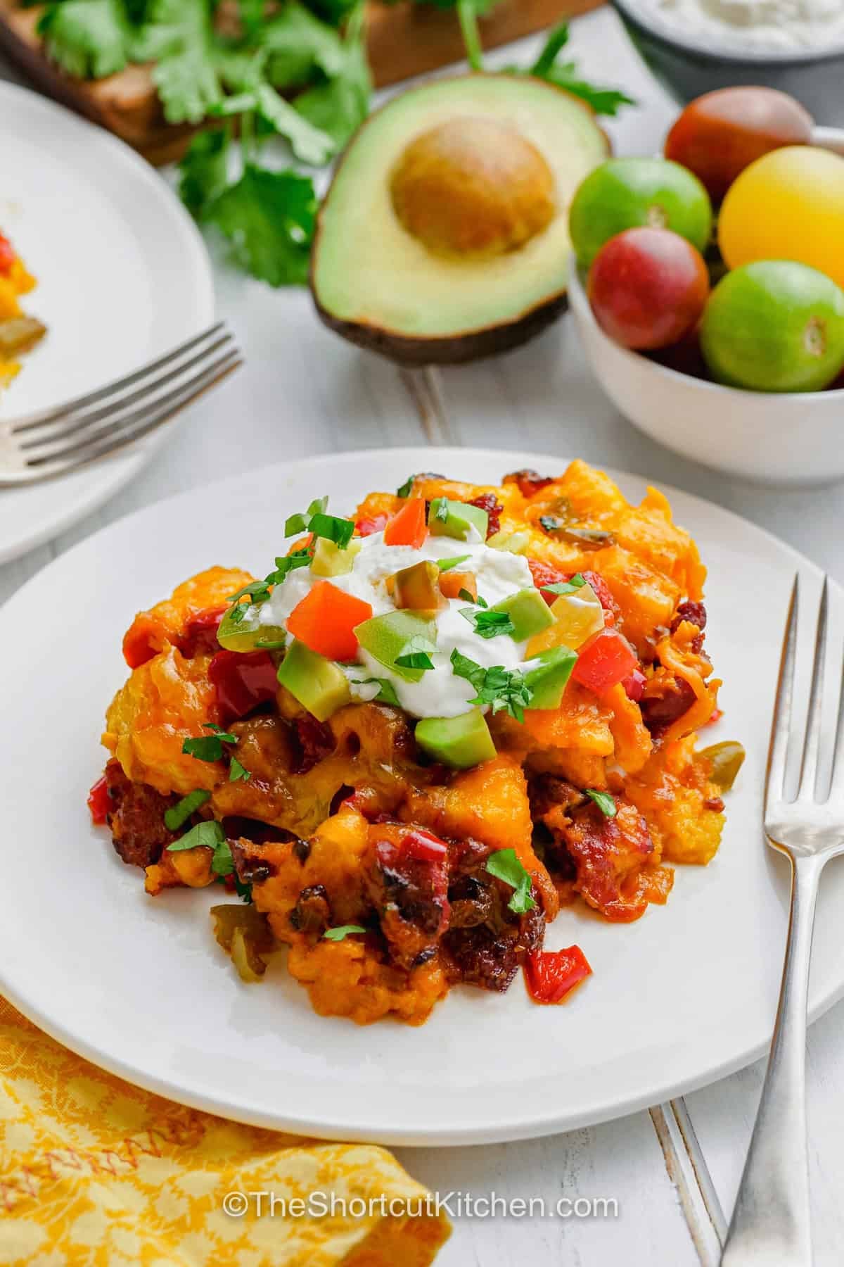 For a cozy breakfast without tying up the oven, make this Slow Cooker breakfast strata with French bread, chorizo, eggs, peppers, and sharp cheddar. The bread soaks up the creamy egg mixture while the slow cooker gently cooks everything until tender and set. Sour cream, avocado, lime, tomato, and cilantro add a fresh finish to this savory breakfast casserole. Pin this easy slow cooker brunch recipe. #theshortcutkitchen a serving of slow cooker breakfast strata on a plate.