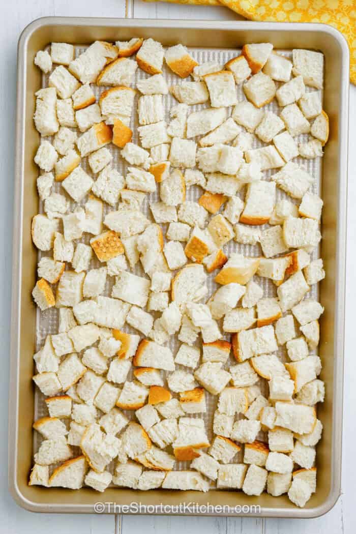Bread cubes on a baking pan.