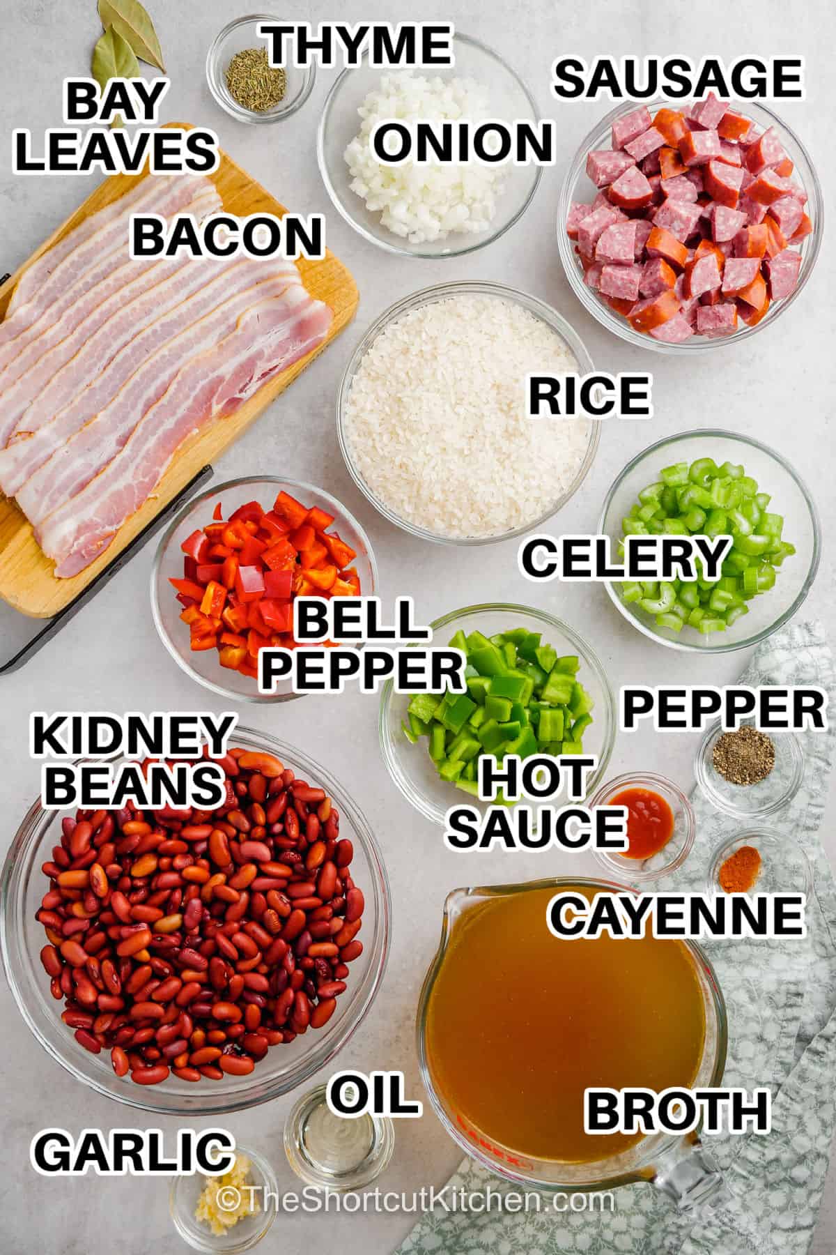 Easy red beans and rice with andouille sausage is big on smoky, savory flavor. Soaked kidney beans cook on the stovetop with bacon, sausage, onion, celery, bell peppers, chicken broth, thyme, cayenne, and hot sauce until deliciously tender. Spoon the creamy beans over white rice for a hearty dinner made from simple ingredients. Pin this cozy red beans and rice recipe for later. #theshortcutkitchen bacon , sausage ,kidney beans , bay leaves , thyme , onion , rice , celery , belle pepper , pepper , hot sauce , cayenne , broth , oil , garlic with labels to make Easy Red Beans and Rice .